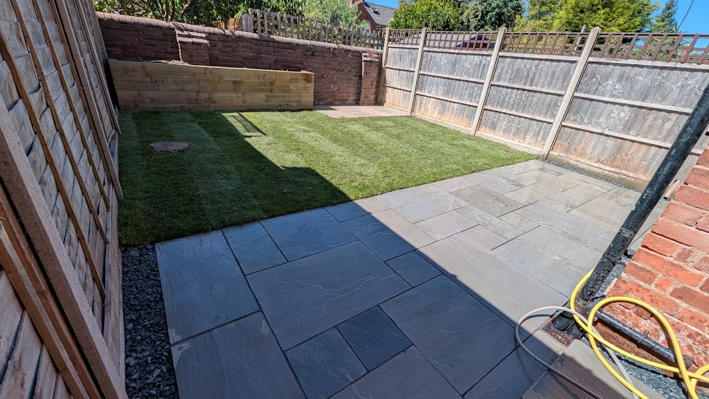 Sandstone patio next to a lawn